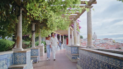 romantic spouses strolling alley city view park. loving man kissing woman hand