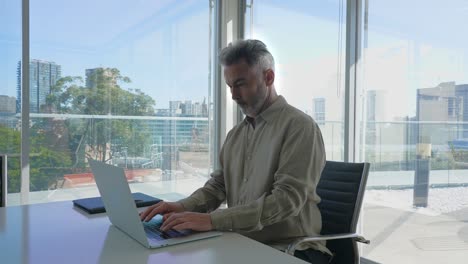 un hombre de negocios usando una computadora portátil en una sala de juntas.