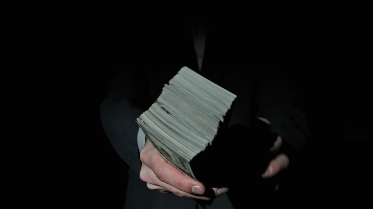 흑색 배경에 남성의 손에 인 1만 달러 어리.