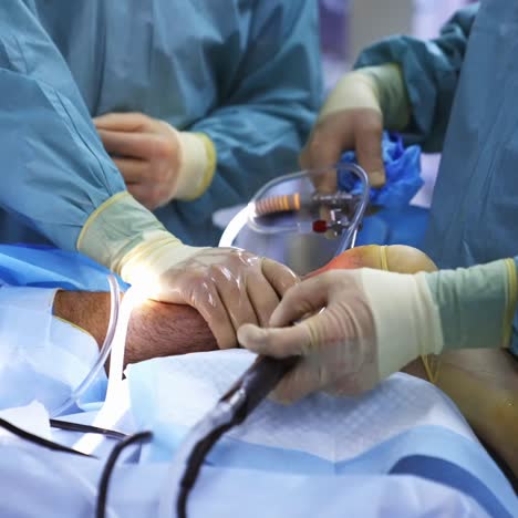 patient undergoing surgery at hospital. cooperative team of doctors performing surgical procedure in operating room