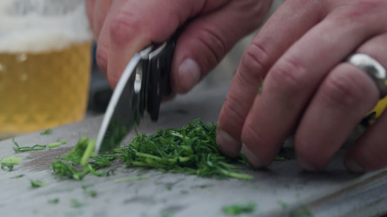 Dill chopped in slow motion with sharp folding knife