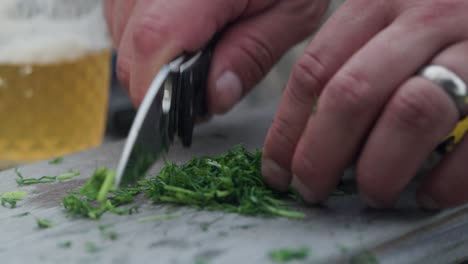 dill chopped in slow motion with sharp folding knife