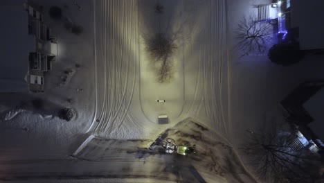 snow plowing equipment working at night, aerial top down view