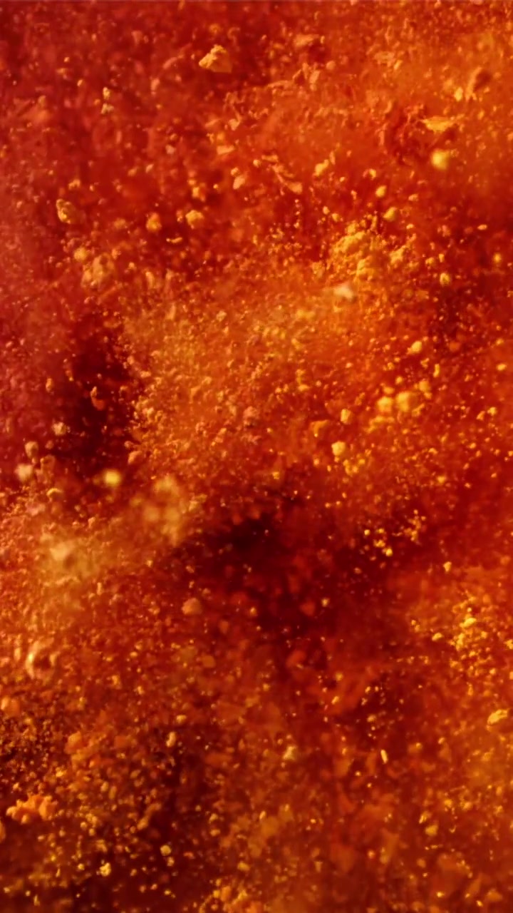 Particelle rosse e arancioni vibranti che turbinano in movimento astratto