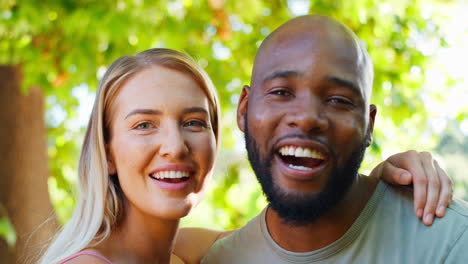 portrait of loving multi-racial couple standing outdoors in garden park or countryside