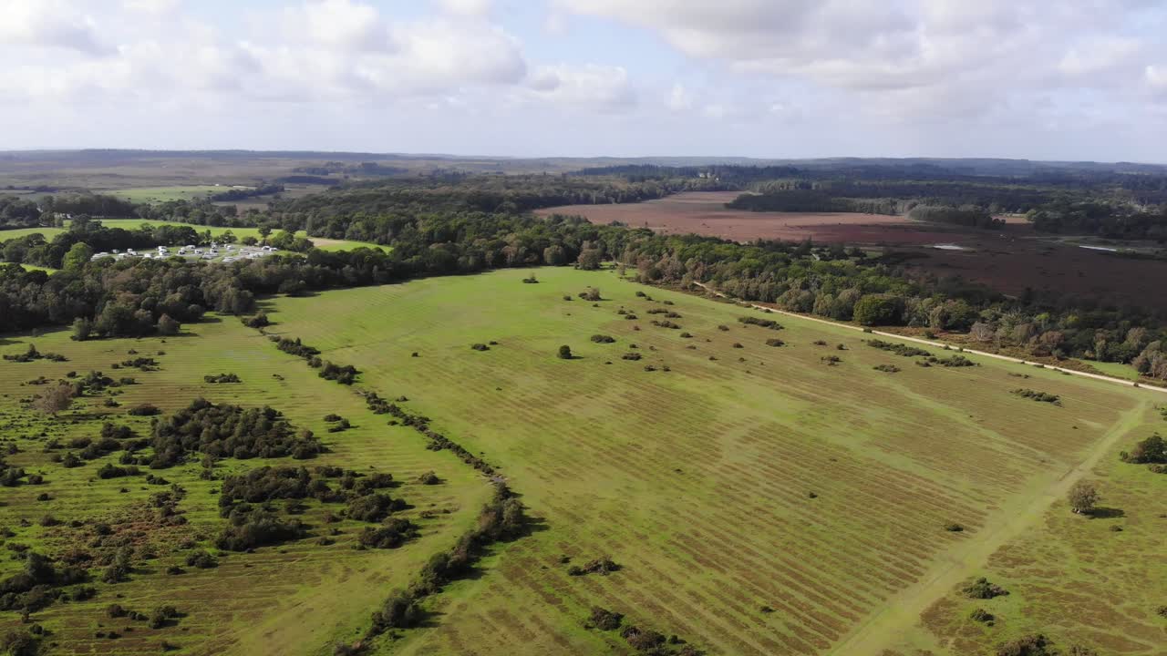 Aerial view of the beautiful landscape of the New Forest National Park in southern England, showcasing its vast greenery and unique terrain. Pan Right Shot