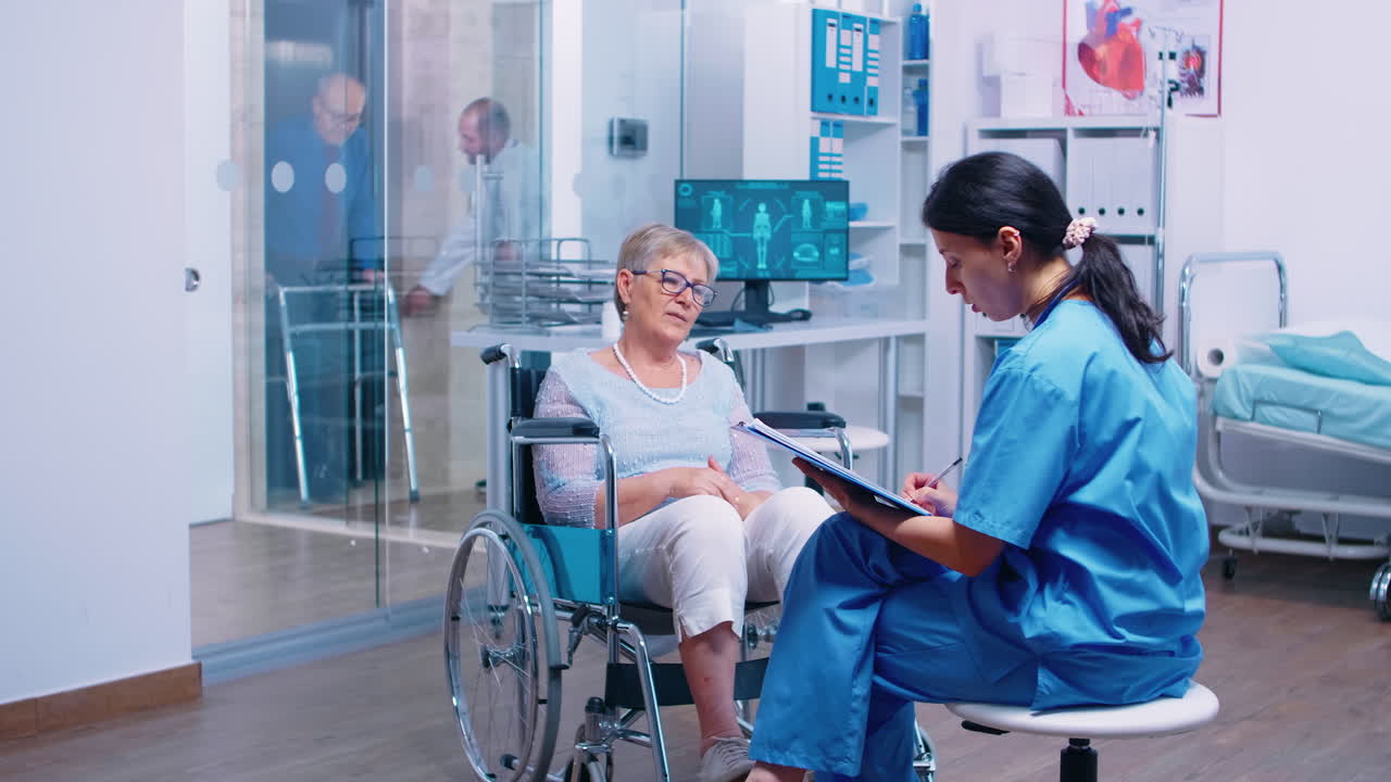 enfermera hablando con una mujer mayor en silla de ruedas
