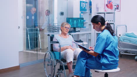 nurse talking with senior woman in wheelchair