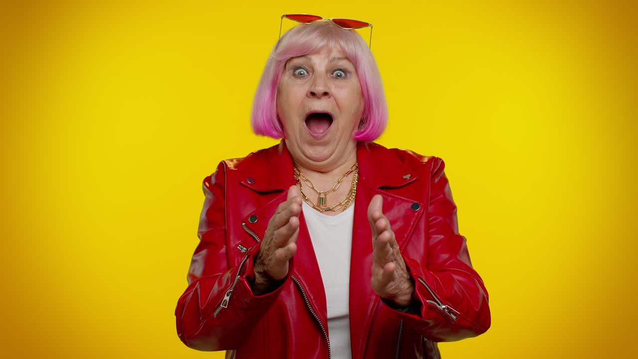 A woman with pink hair and sunglasses is surprised