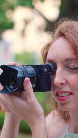 close-up of a woman taking a photo with a mirrorless camera