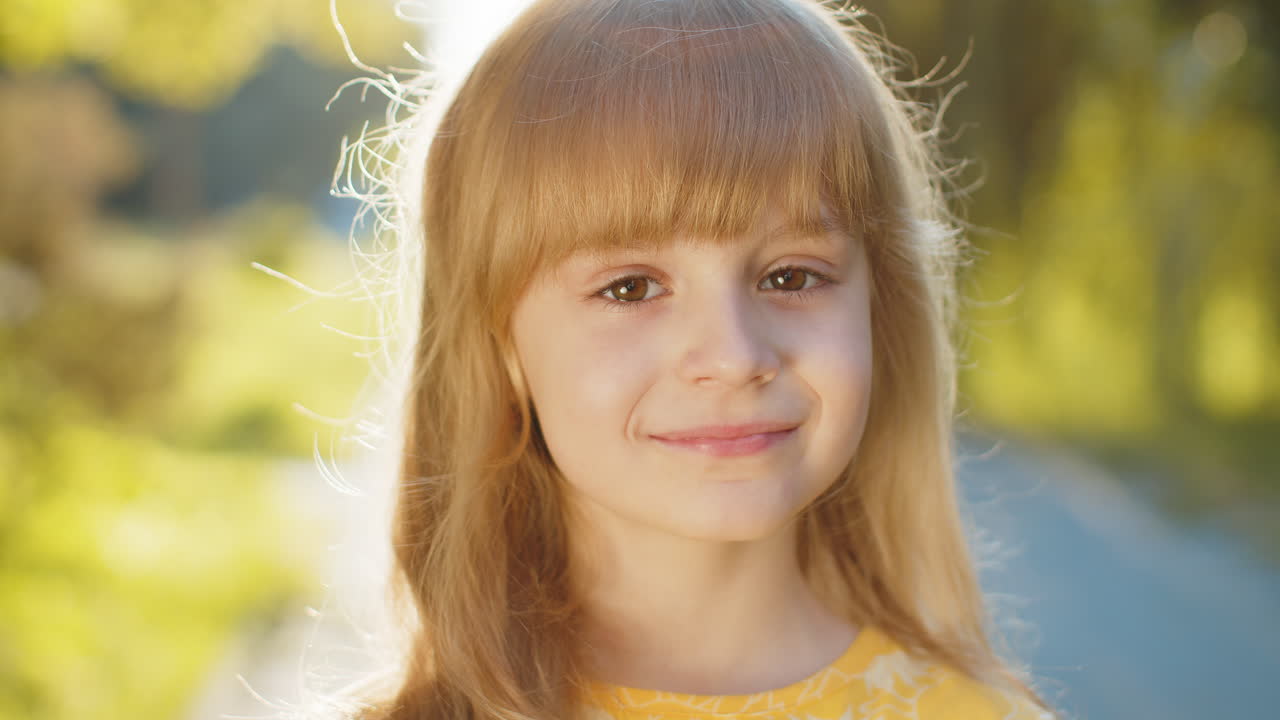 Ritratto di una bambina preadolescente felice con il viso sorridente che guarda la telecamera, di buon umore e soddisfatta nel parco