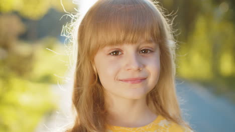 portrait of happy preteen child girl face smiling looking at camera good mood satisfied on park