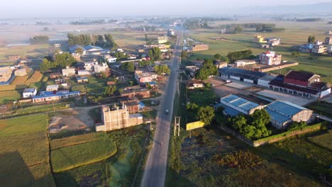 an aerial view of a straight road bordered by houses in the town of nepalgunj