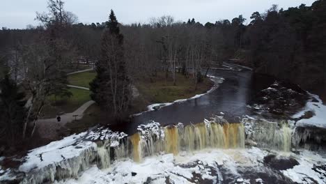 aerial drone view of a frozen waterfall in winter