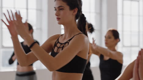 Hermosa-Mujer-Caucásica-De-Yoga-Practicando-Meditación-En-Pose-Guerrera-Con-Un-Grupo-De-Mujeres-Multirraciales-Disfrutando-De-Un-Estilo-De-Vida-Saludable-Haciendo-Ejercicio-En-Un-Gimnasio-Al-Amanecer.