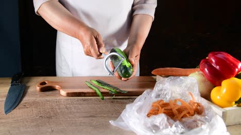 a woman hands peel fresh Cucumber