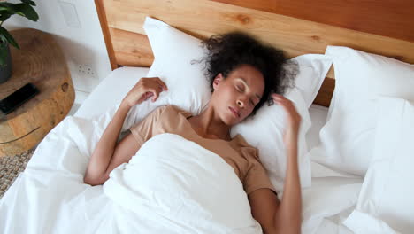 woman sleeping peacefully in bed, resting head on soft white pillow, at home