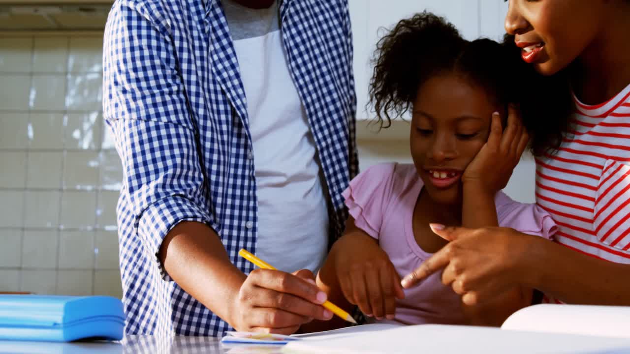Genitori che aiutano la figlia con i compiti