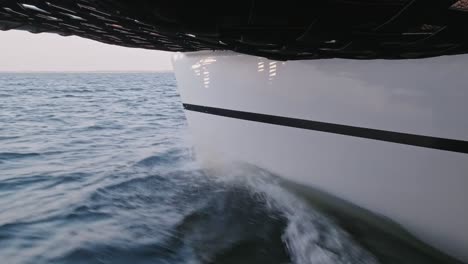 toma estática bloqueada del casco blanco del catamarán navegando a través del oleaje del océano en calma