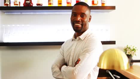 Portrait-of-man-standing-with-arms-crossed-in-restaurant