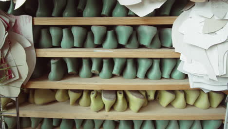 estantes con zapatillas y patrones en el taller de cordwainer