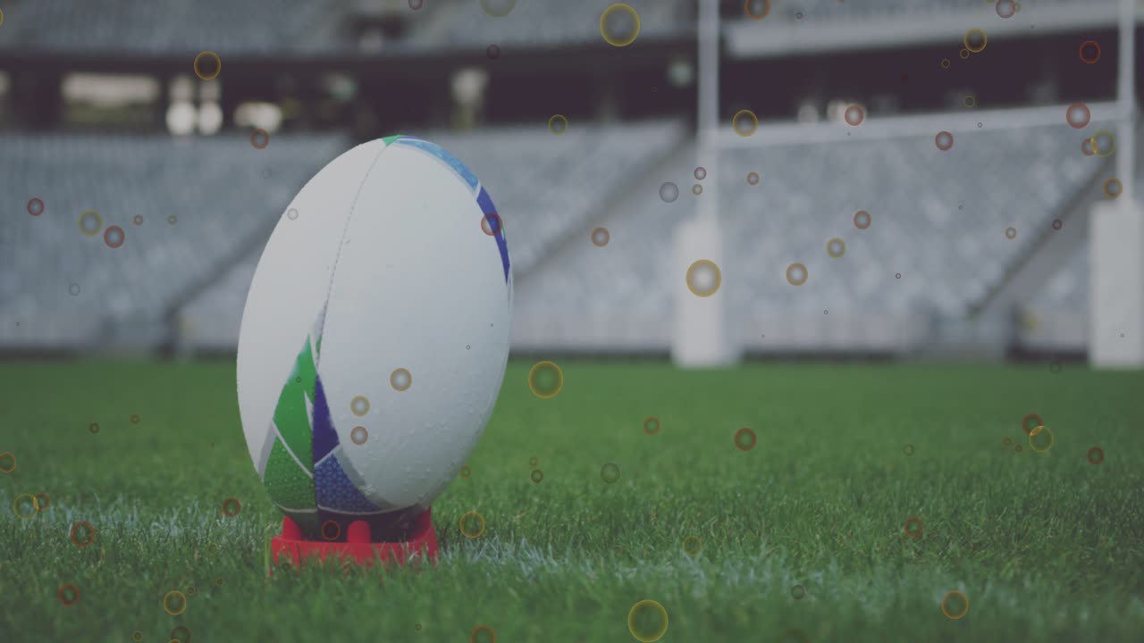 Sequência iniciando com bola de rugby girando para a esquerda em um tee na linha de marcação, com partículas flutuando e mostrando painéis.