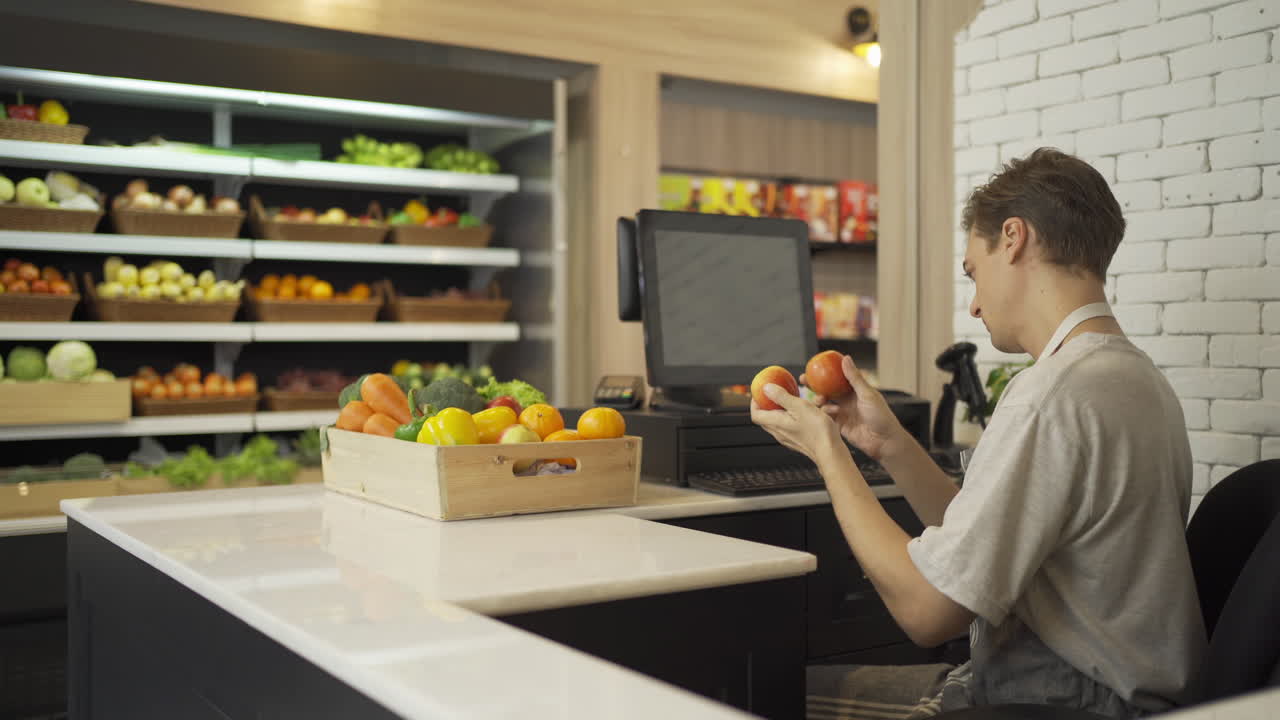 cajero de una tienda de comestibles comprobando frutas
