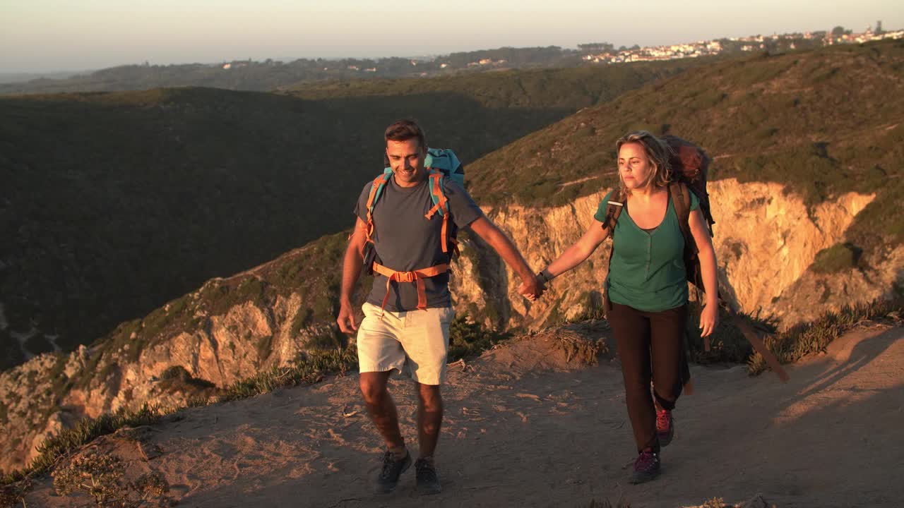 pareja casada de mediana edad de turistas caminando por el camino de la montaña