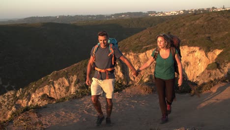 middle aged married couple of tourists walking on mountain path