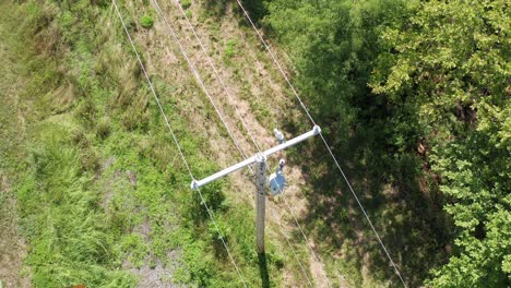 toma panorámica aérea extrema de primer plano de un poste de servicios públicos rural e inspección de líneas eléctricas