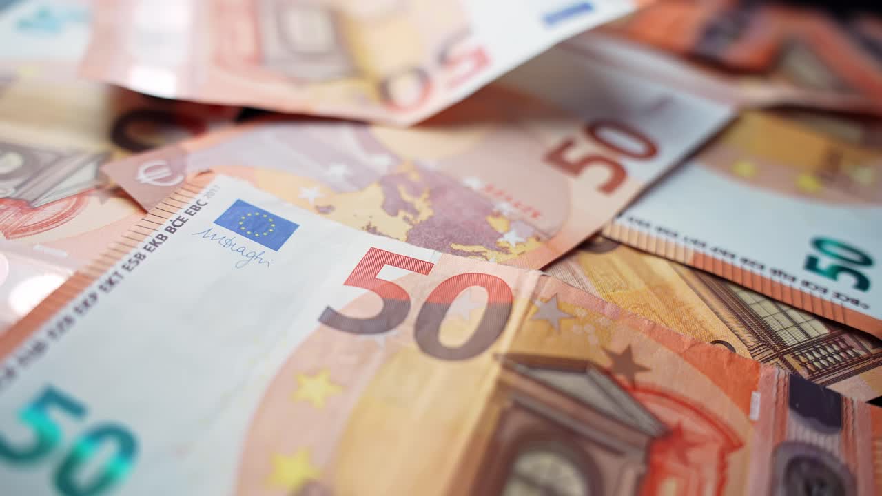 Makrobilde av overlappende 50 euro-sedler på et bord med grunn dybdeskarphet, ideelt for finans-, betalings-, budsjetterings-, inflasjons- og forretningskontantstrøm-konsepter.
