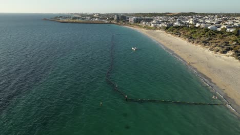 Luftaufnahme-Des-Strandes-Von-Coogee-Mit-Schützendem-Haifischnetz,-Das-Spielende-Kinder-Im-Wasser-An-Sonnigen-Tagen-Schützt