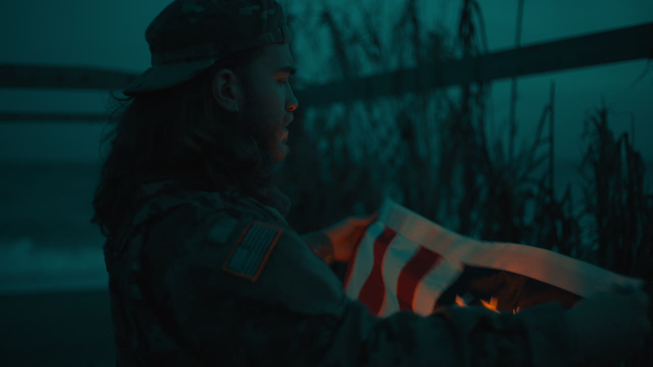 Soldat samler amerikansk USA-flag i provisorisk udposthytte på Memorial Day