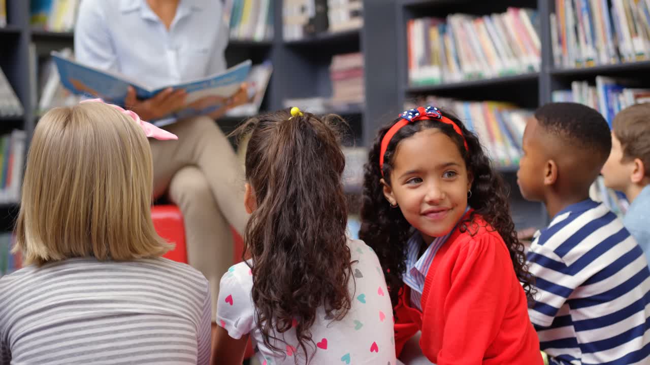 vista lateral de una estudiante asiática mirando hacia atrás y sonriendo en la biblioteca de la escuela 4k