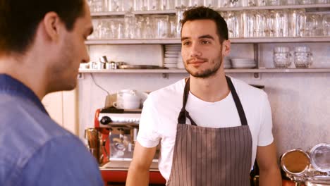 waiter interacting with customer at counter