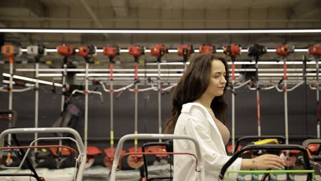 portrait of a female garden tool store consultant. buying a lawnmower. tools for gardening.
