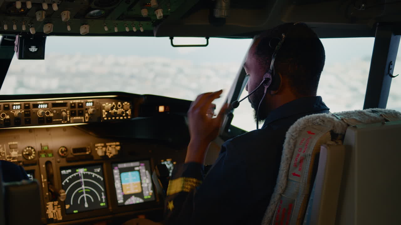 African american copilot flying airplane with captain in cockpit