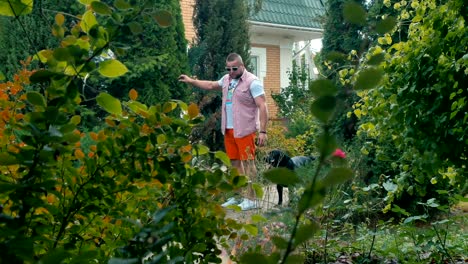 young man walks around with his dog in the house courtyard