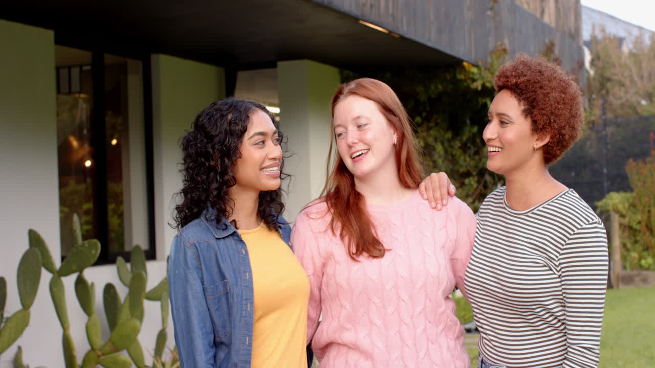 Standing together and smiling, diverse female friends enjoying outdoor hangout