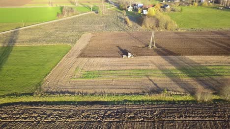 farmland with tractor plowing dirt in pattern