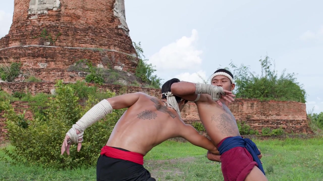 To traditionelle Muay Boran-kæmpere træner kampsport ved de historiske Ayutthaya-ruiner i Thailand