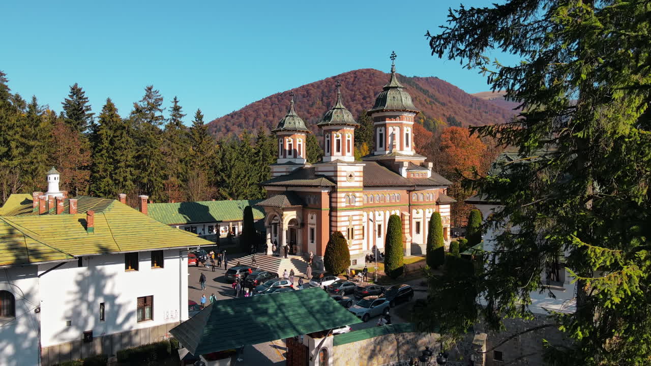 Aerial drone view of Sinaia Monastery in Romania. Monastery in Carpathians with inner court, church, tourists and forest around it