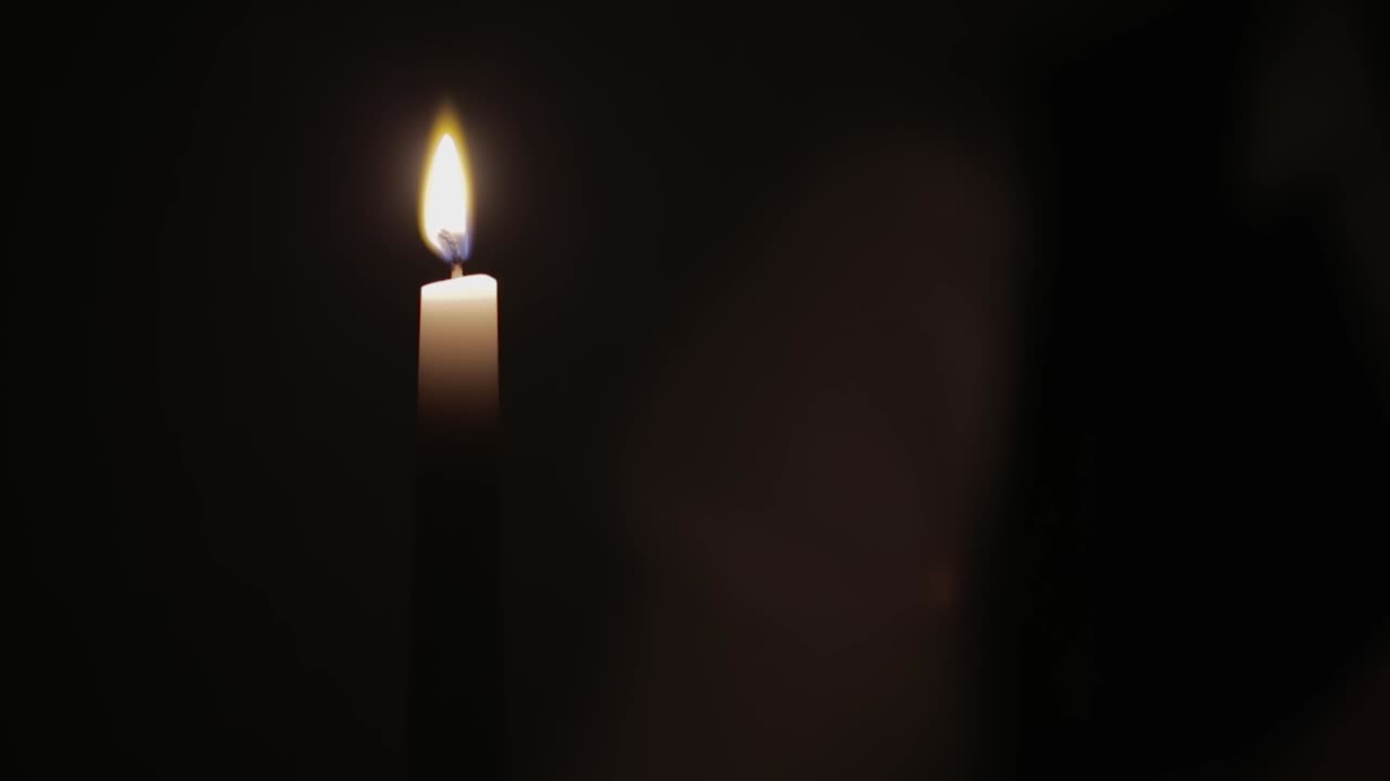 une personne allume une bougie avec une allumette