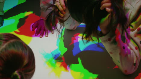 colorful hands of children having fun playing in multicolor light kids enjoying playful game with rainbow color silhouettes