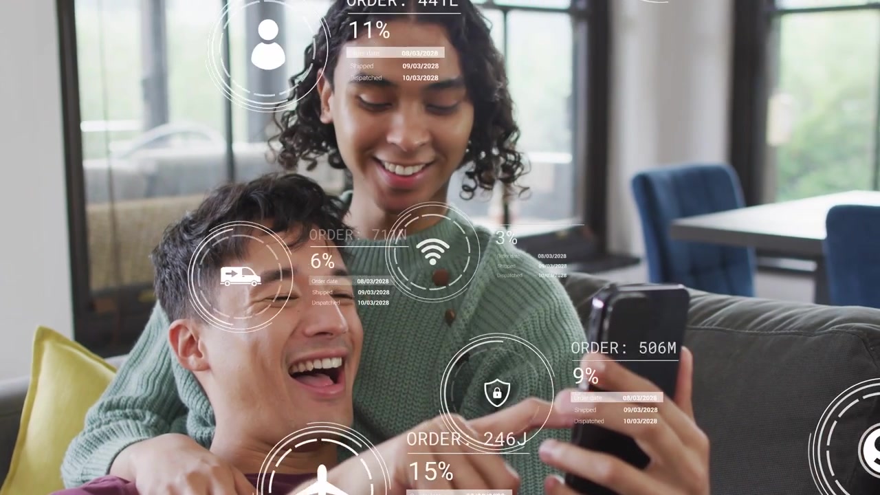 Man reclining and nonbinary partner leaning on couch tapping phone, sharing AR finance HUD icons