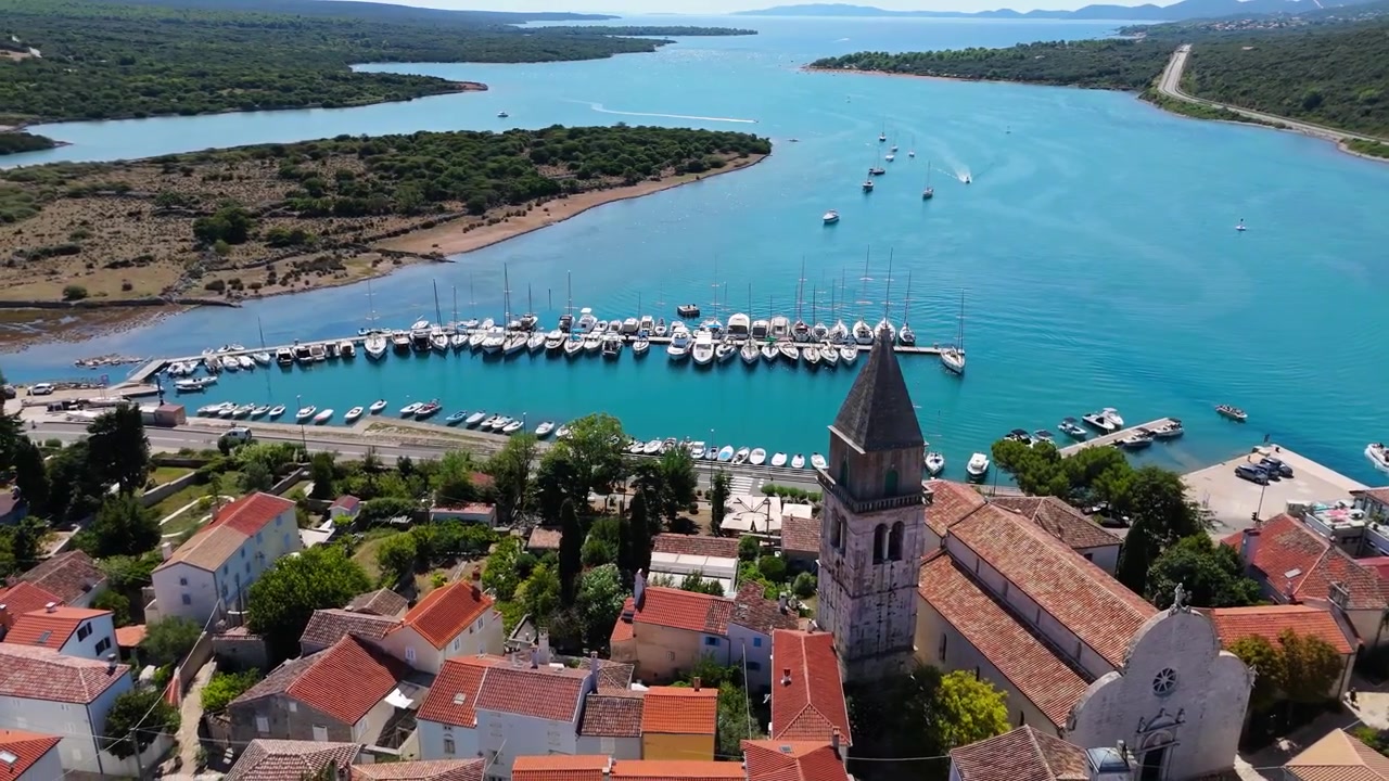 Panorama della città di Osor sull'isola di Cherso, Croazia, in una splendida giornata estiva. Le viste aeree mostrano il centro storico, spiagge soleggiate, yacht a vela, il porto turistico e campeggi vicini sulla costa adriatica mediterranea