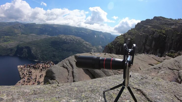 Phone camera on tripod with lens attached at Norway fjord viewpoint