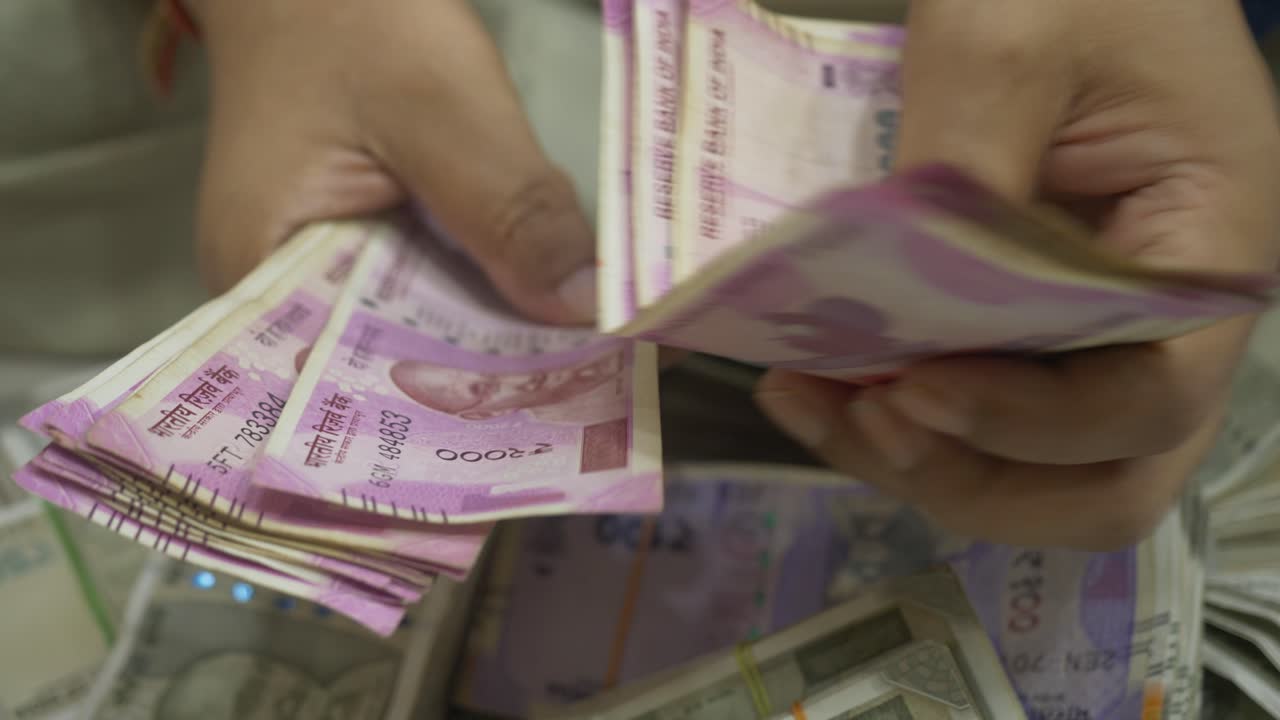 An Indian businessman counting 2000 Rupee banknotes, Cash in Hand Closeup, India, Selective focus