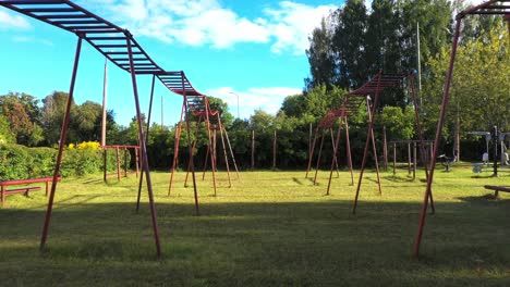 Old-steel-made-outdoor-gym-in-local-park,-dolly-forward-view