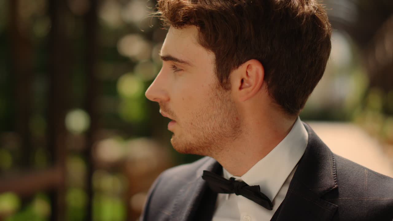 아치  ⁇ 에 서 있는 혼란스러운 신랑. 공원에서 신부를 기다리는 스트레스를 받은 남자